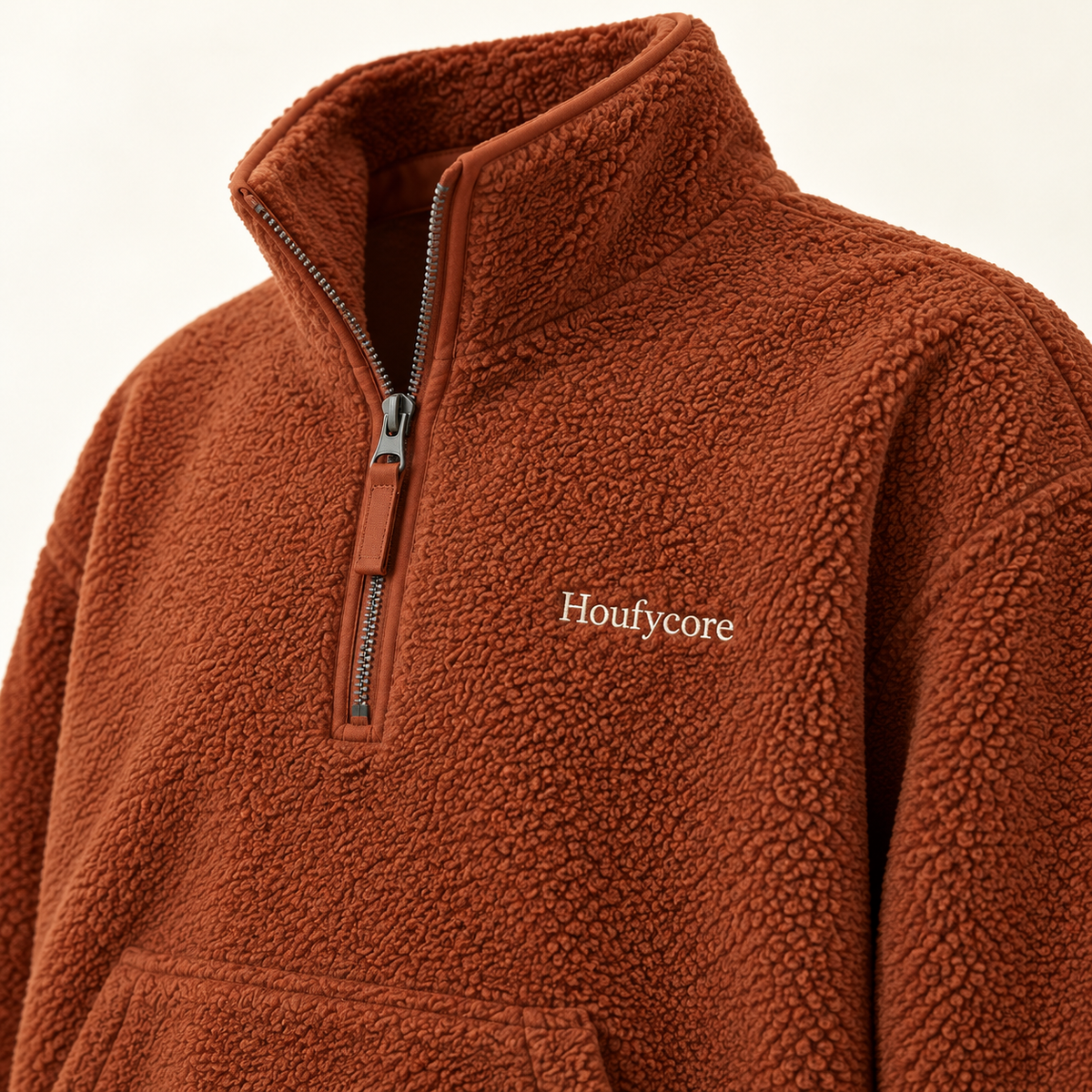 Close-up of the Rust Ember fleece, showing the half zipper, textured fabric and Houfycore chest embroidery.
